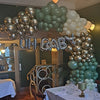 Organic Demi Arch:  Latex balloon in blocked in Green, Gold and Ivory in various sizes, with foil letters spelling 'oh baby' attached to the top of the demi arch.